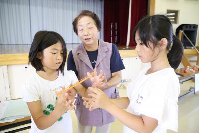 遊び方を教わりながらあやとりに挑...