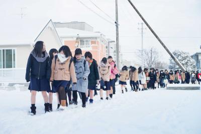 列を作って慎重に歩いて登校する生...